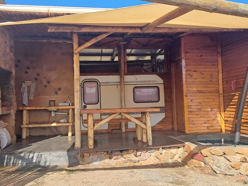 The BushCat caravan under its timber roof with the patio in front