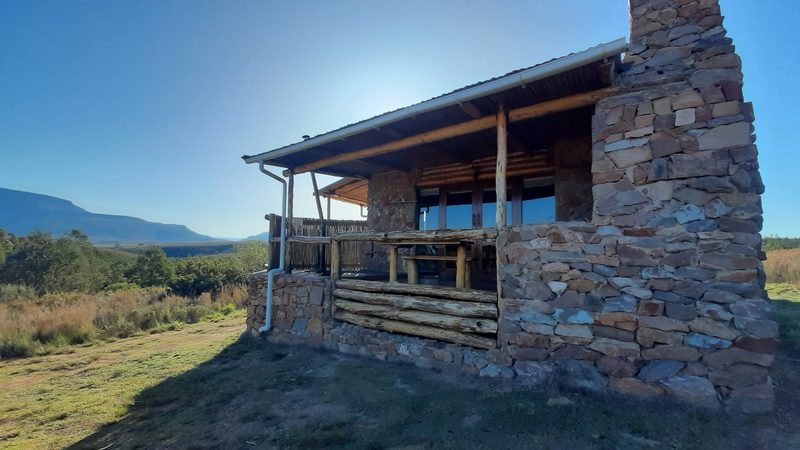 Meerkat log cabin with its stone chimney under a blue sky