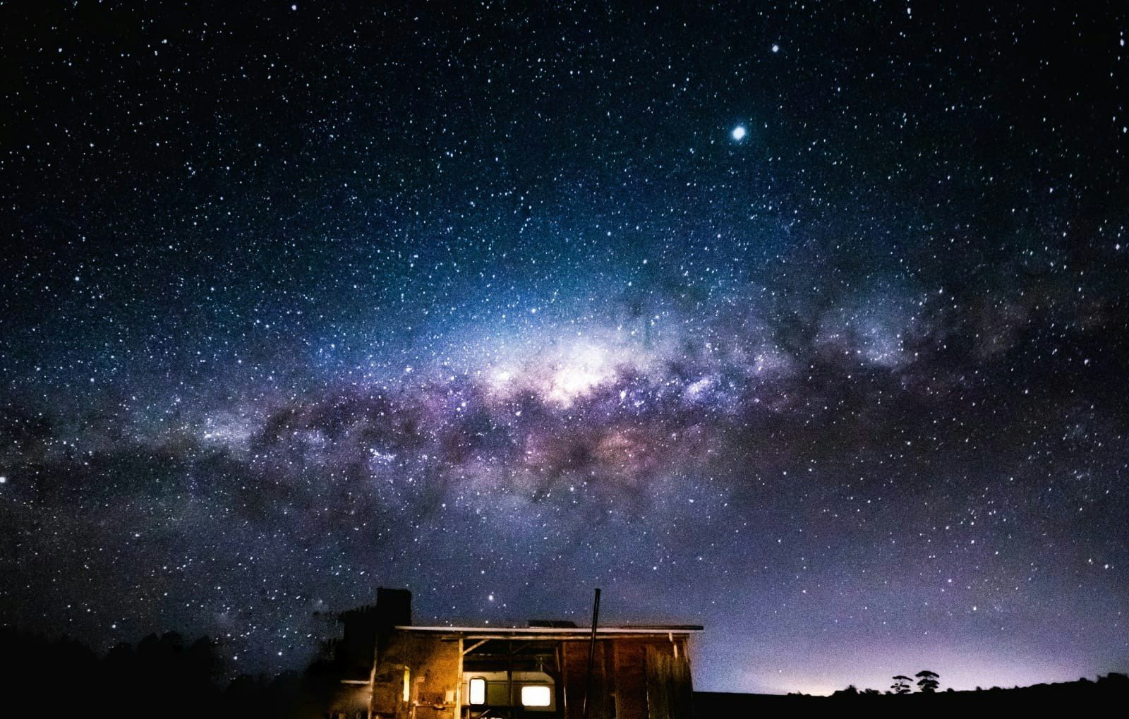 The Milky Way arching over one of the units, its windows lit