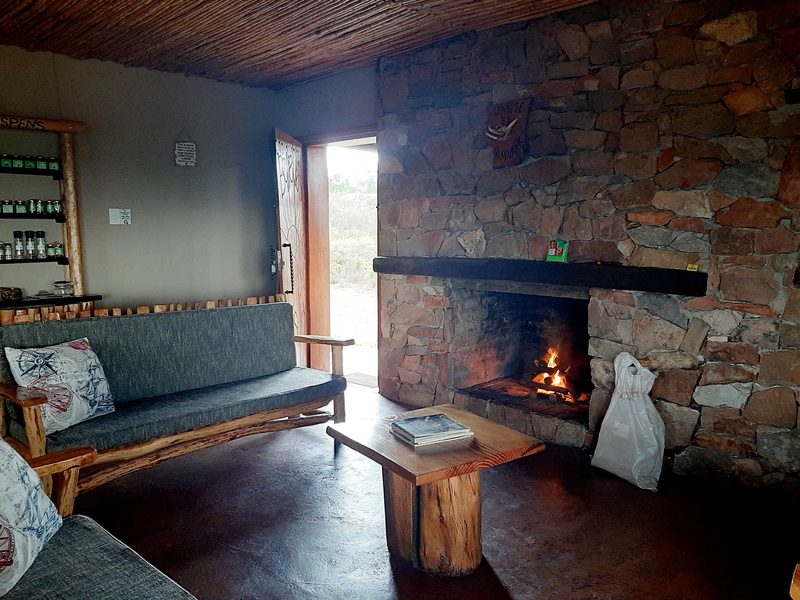 Vlakvark's open-plan lounge with the fire burning in the stone fireplace